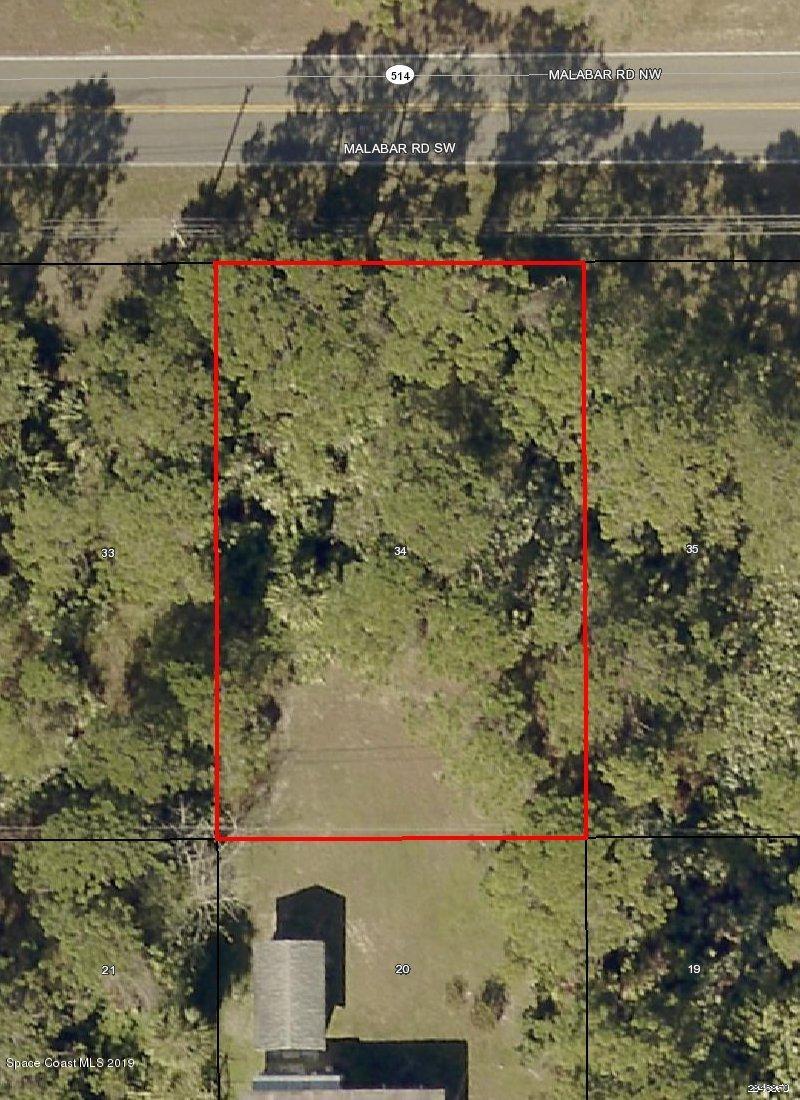 1112 Malabar Road Southwest Palm Bay, FL 32908 - Photo 1 of 2 a aerial view of a house with a yard and large trees