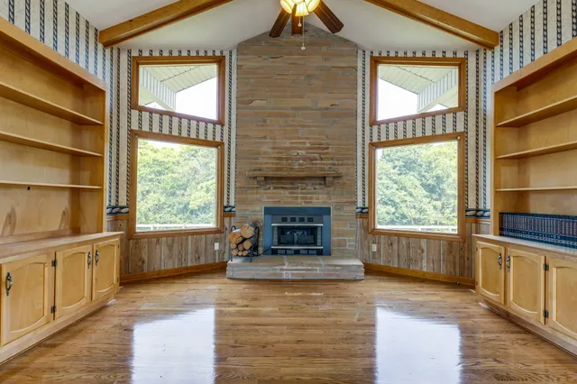 an empty room with wooden floor and a window