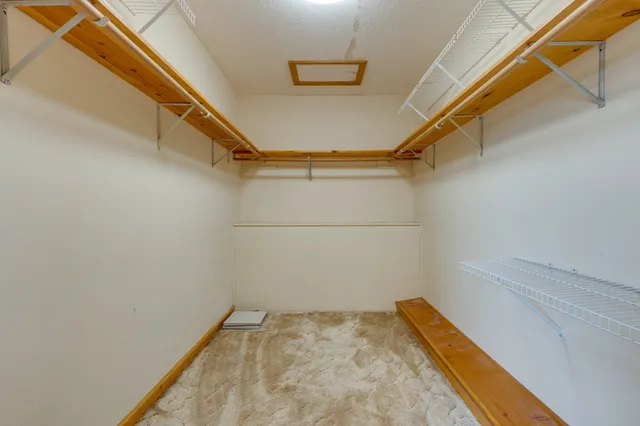 a view of an empty room with closet and a window