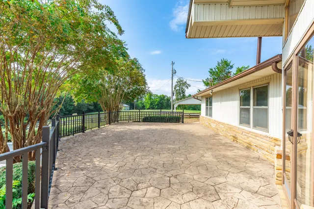 a view of a backyard with brick wall and a large tree