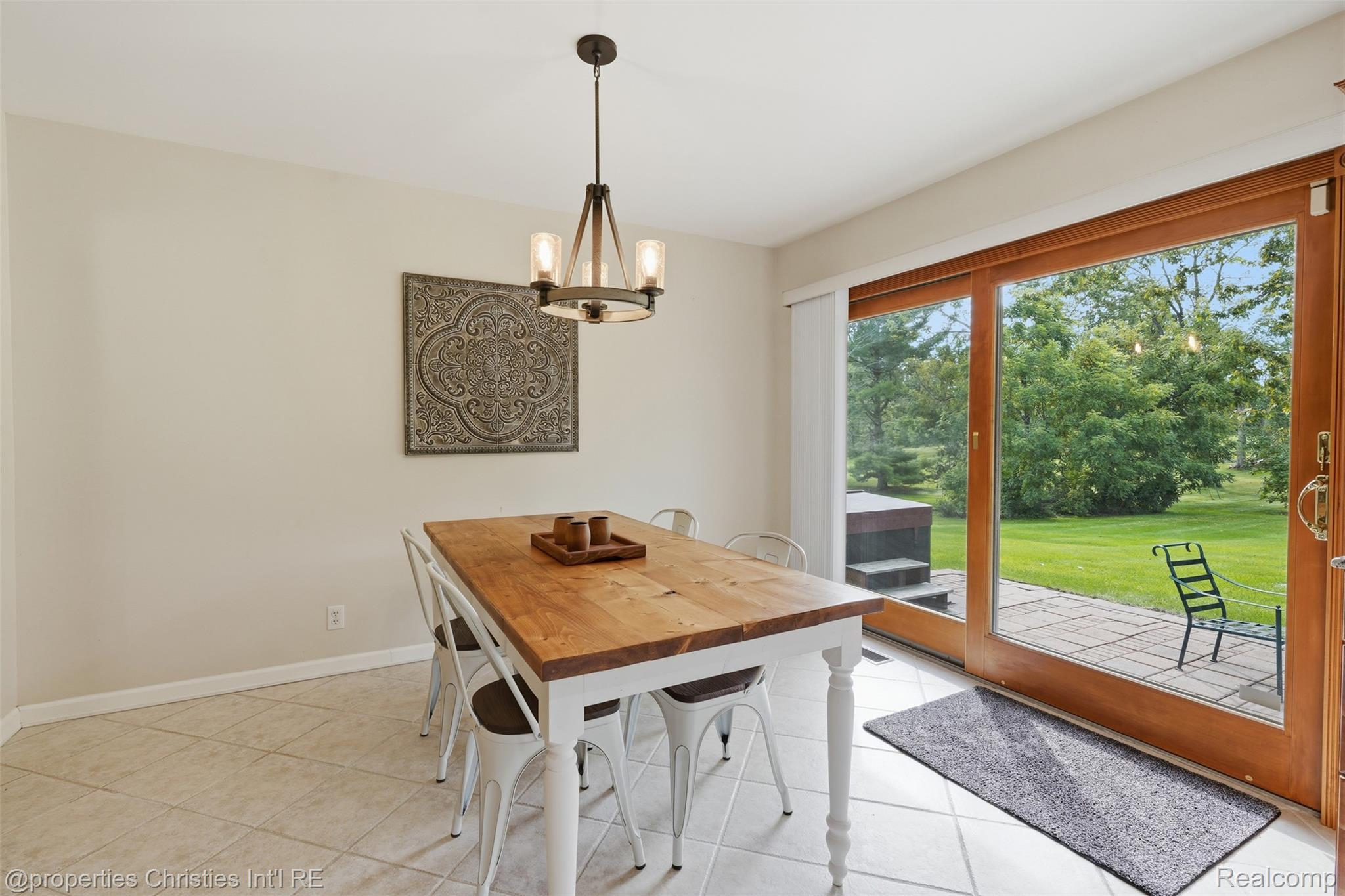 4030 Textile Road Ypsilanti, MI 48197 - Photo 12 of 58 Tiled flooring, wood-finish dining table, chandelier lighting, sliding glass doors, and exterior patio with green space