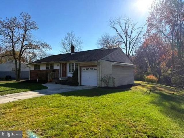 a view of a house with a big yard with large tree