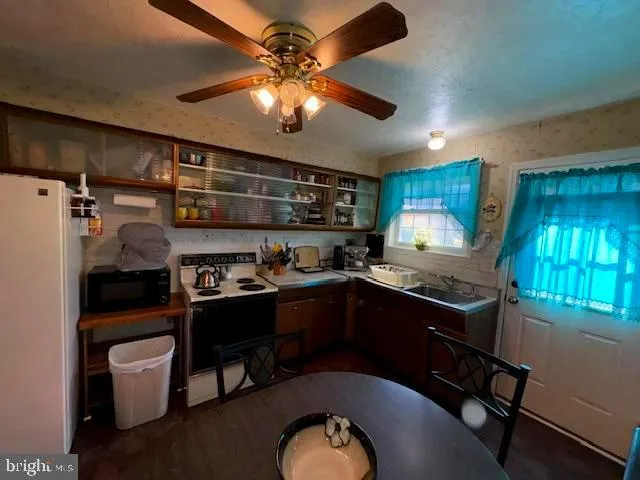a kitchen with stainless steel appliances granite countertop a sink a stove cabinets and a dining table