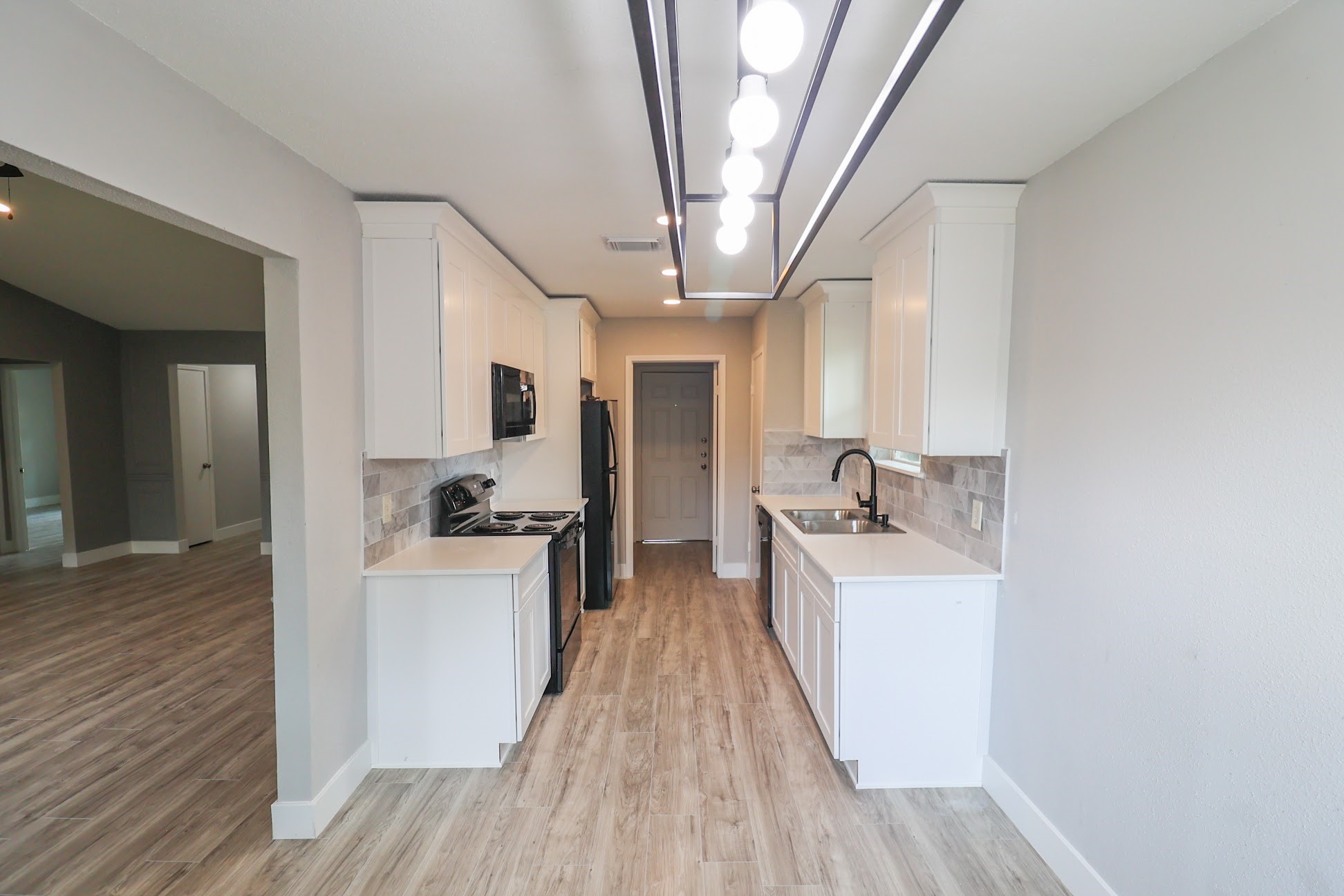 5027 Monteith Drive Spring, TX 77373 - Photo 7 of 28 a view of a kitchen with a sink dishwasher a refrigerator with wooden floor
