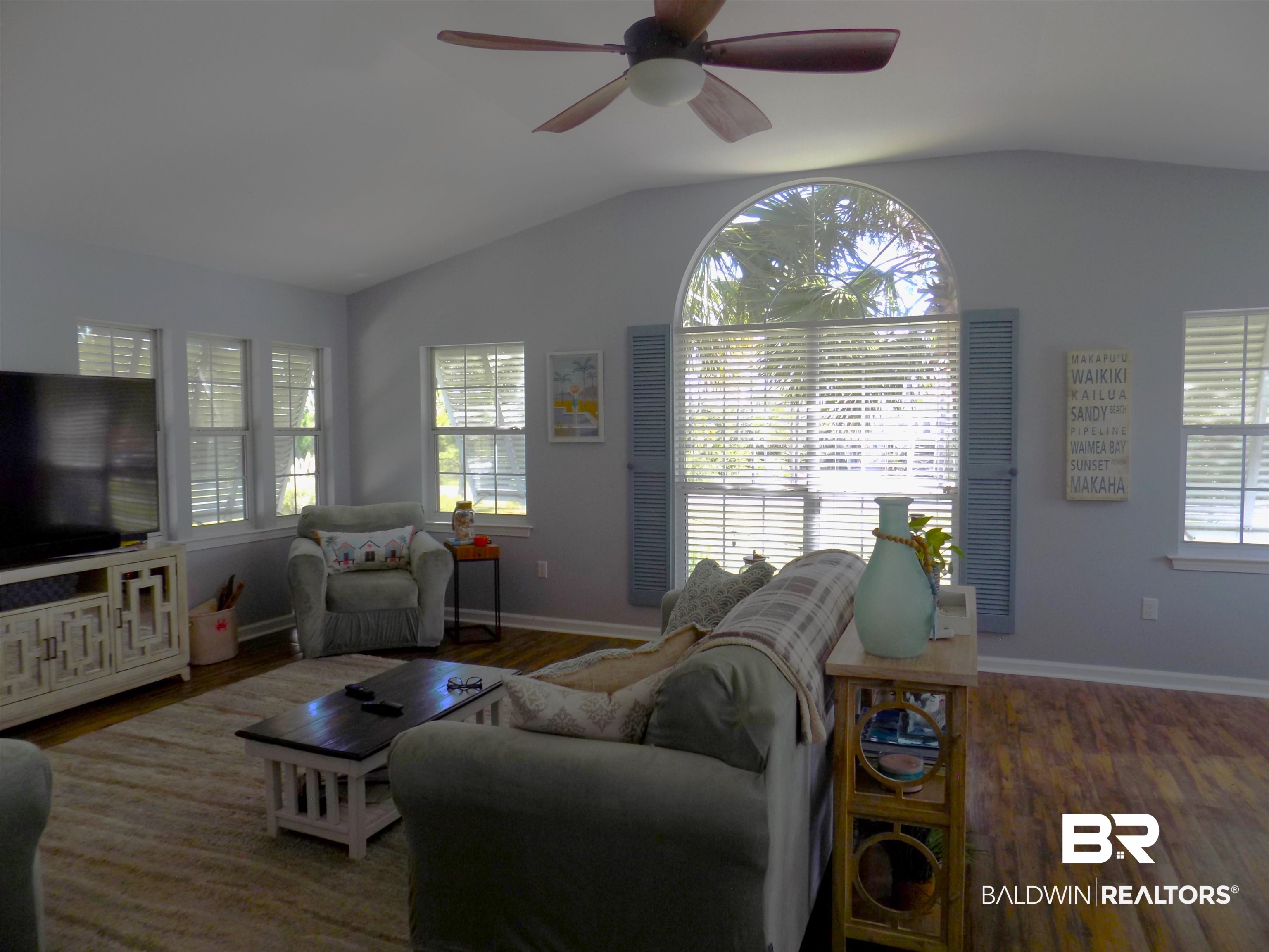 304 Windmill Ridge Road Gulf Shores, AL 36542 - Photo 4 of 29 Living area featuring plenty of natural light, lofted ceiling, wood finished floors, and ceiling fan