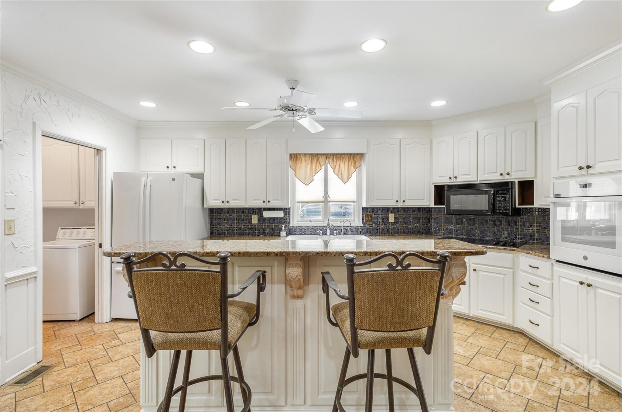 3524 Highview Road Charlotte, NC 28210 - Photo 17 of 34 a kitchen with stainless steel appliances granite countertop a stove a sink a microwave a refrigerator and white cabinets with wooden floor