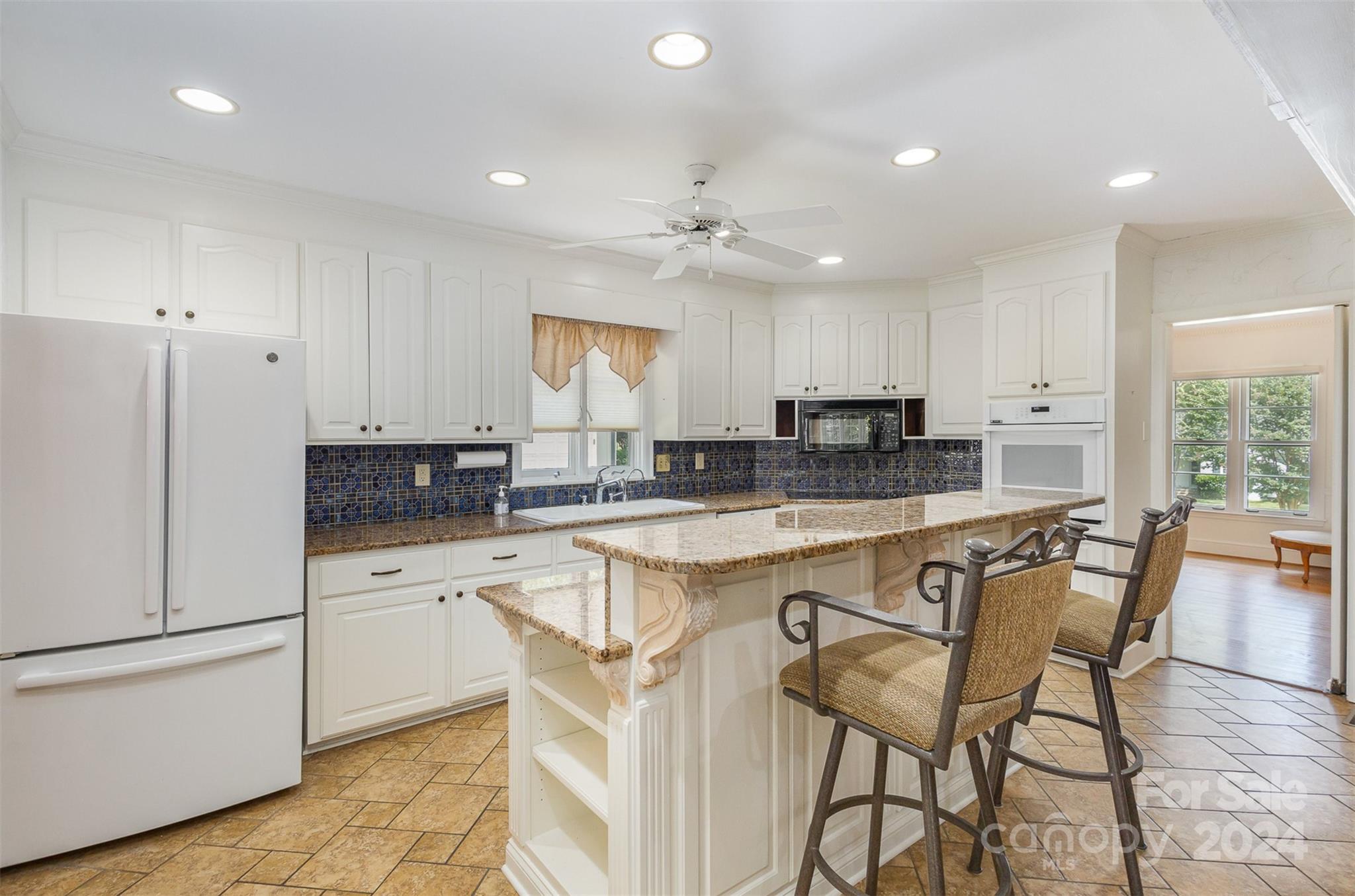 3524 Highview Road Charlotte, NC 28210 - Photo 6 of 34 a kitchen with stainless steel appliances granite countertop a stove a sink a refrigerator and white cabinets with wooden floor