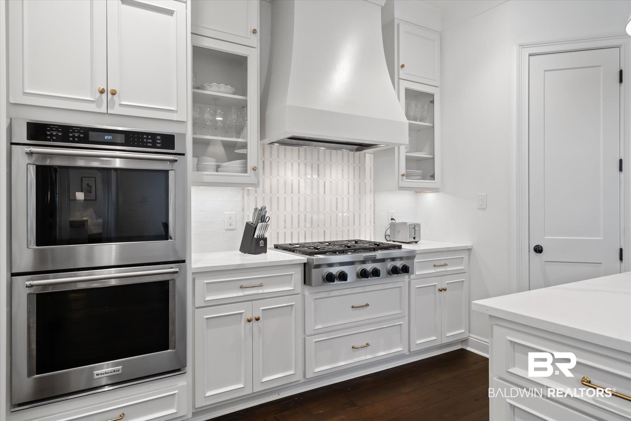 3713 Old Shell Road Mobile, AL 36608 - Photo 13 of 52 Kitchen featuring decorative backsplash, white cabinetry, stainless steel appliances, and custom range hood