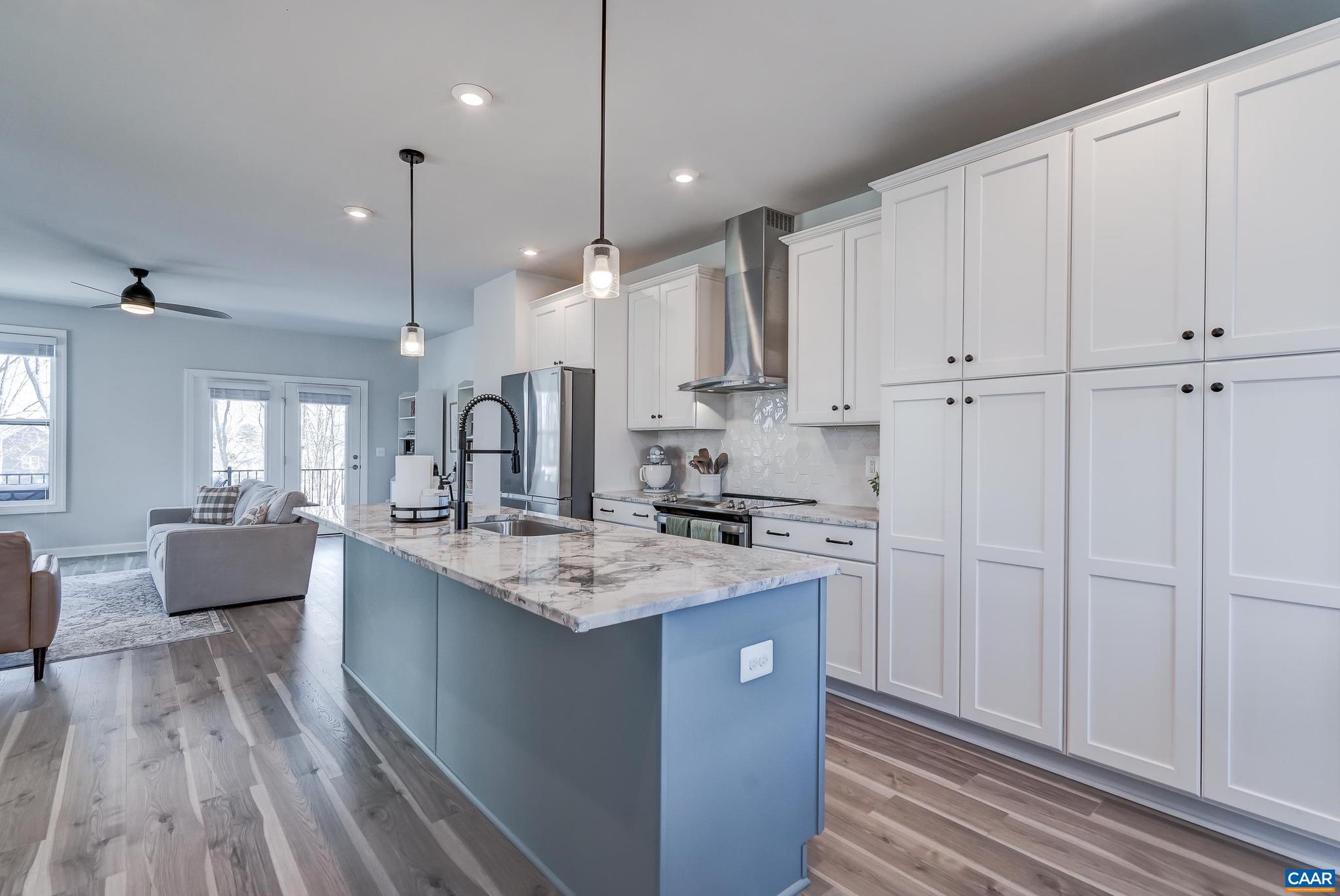 1816 Fowler Street Charlottesville, VA 22901 - Photo 11 of 51 a kitchen with kitchen island granite countertop a sink cabinets and wooden floor