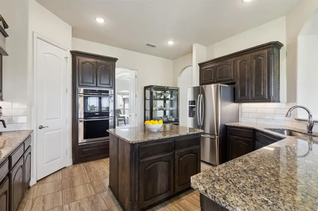 a kitchen with stainless steel appliances granite countertop a refrigerator a stove a sink a oven and dishwasher