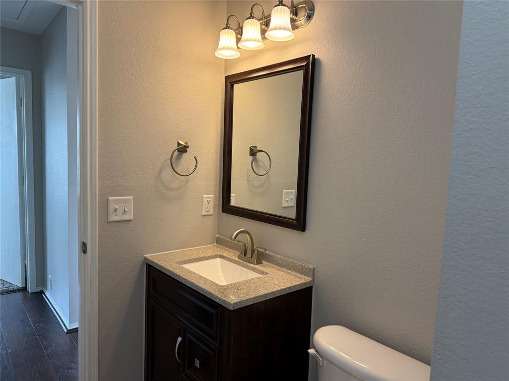 4514 Quail Run Road Sherman, TX 75092 - Photo 8 of 34 Bathroom featuring a textured wall, vanity, and dark wood finished floors