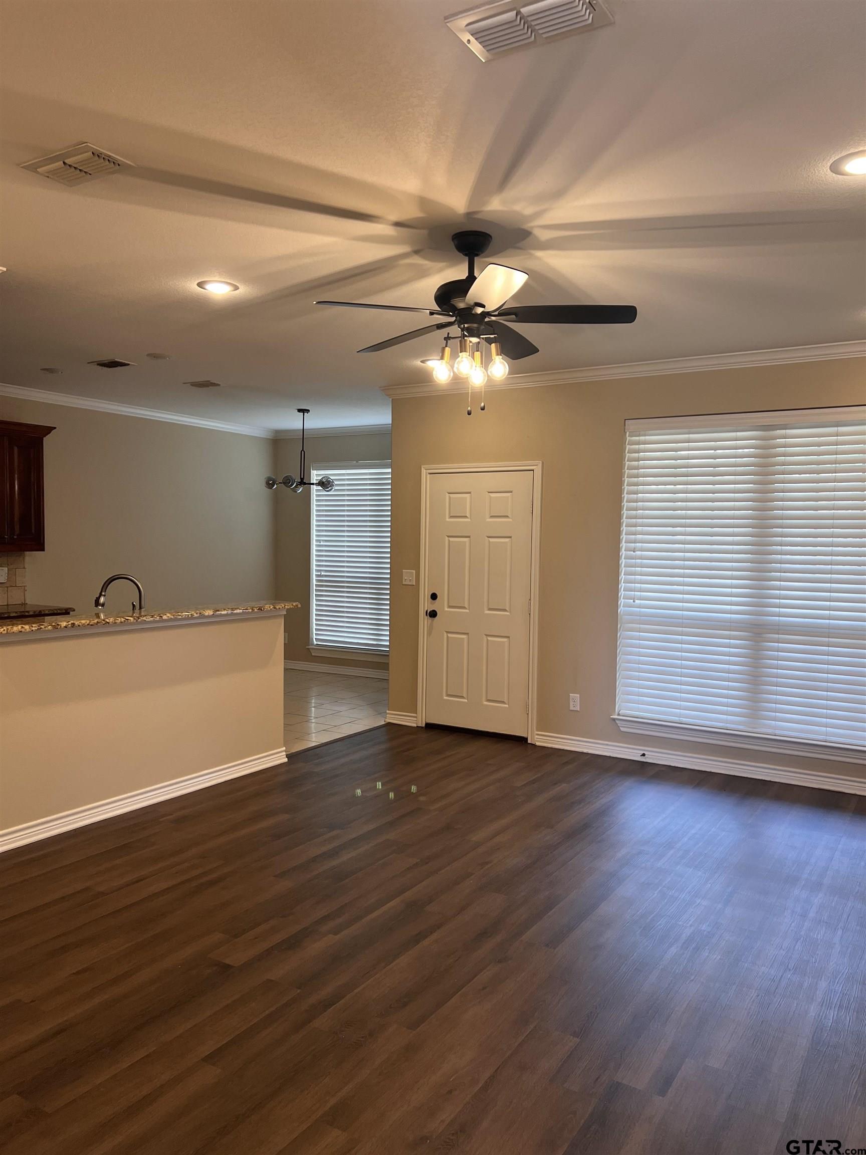 112 Letha Court Tyler, TX 75702 - Photo 18 of 45 a view of an empty room with wooden floor and a ceiling fan