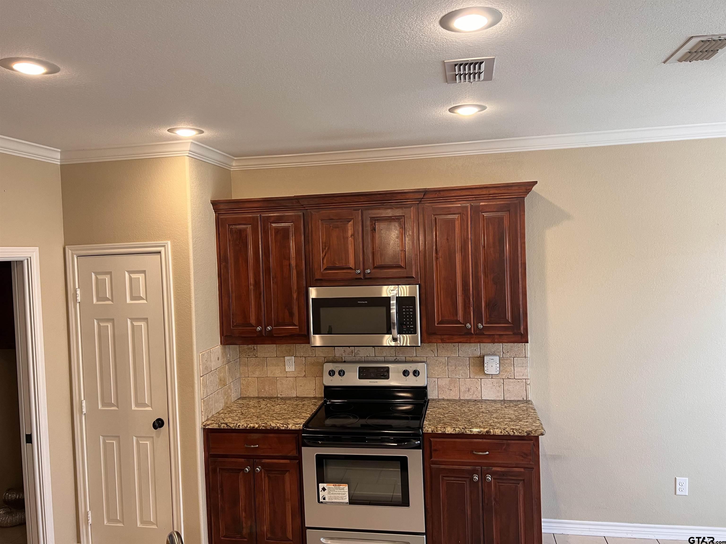 112 Letha Court Tyler, TX 75702 - Photo 25 of 45 a kitchen with stainless steel appliances granite countertop a stove and a microwave