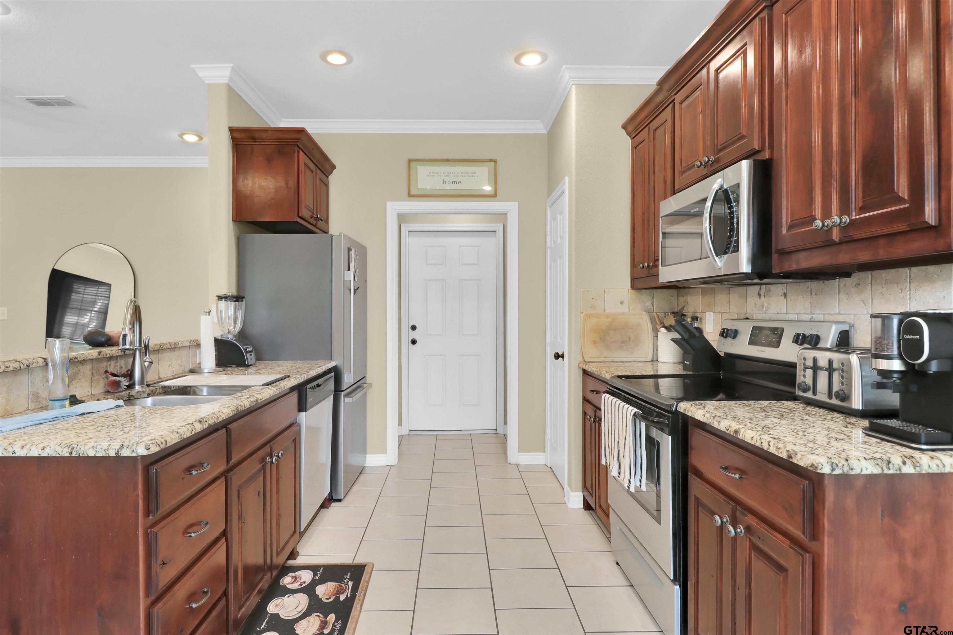 112 Letha Court Tyler, TX 75702 - Photo 39 of 45 a kitchen with stainless steel appliances granite countertop a sink stove and refrigerator