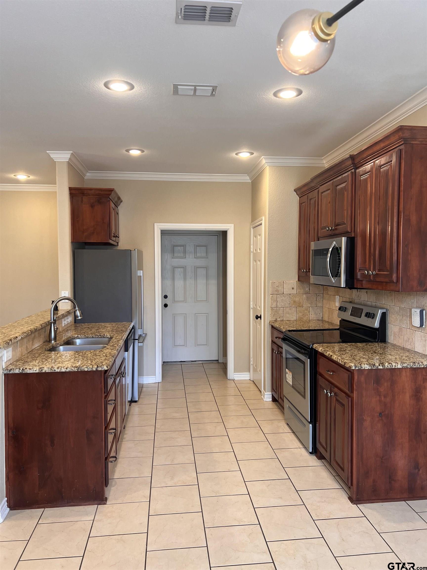 112 Letha Court Tyler, TX 75702 - Photo 10 of 45 a kitchen with stainless steel appliances granite countertop a sink and cabinets