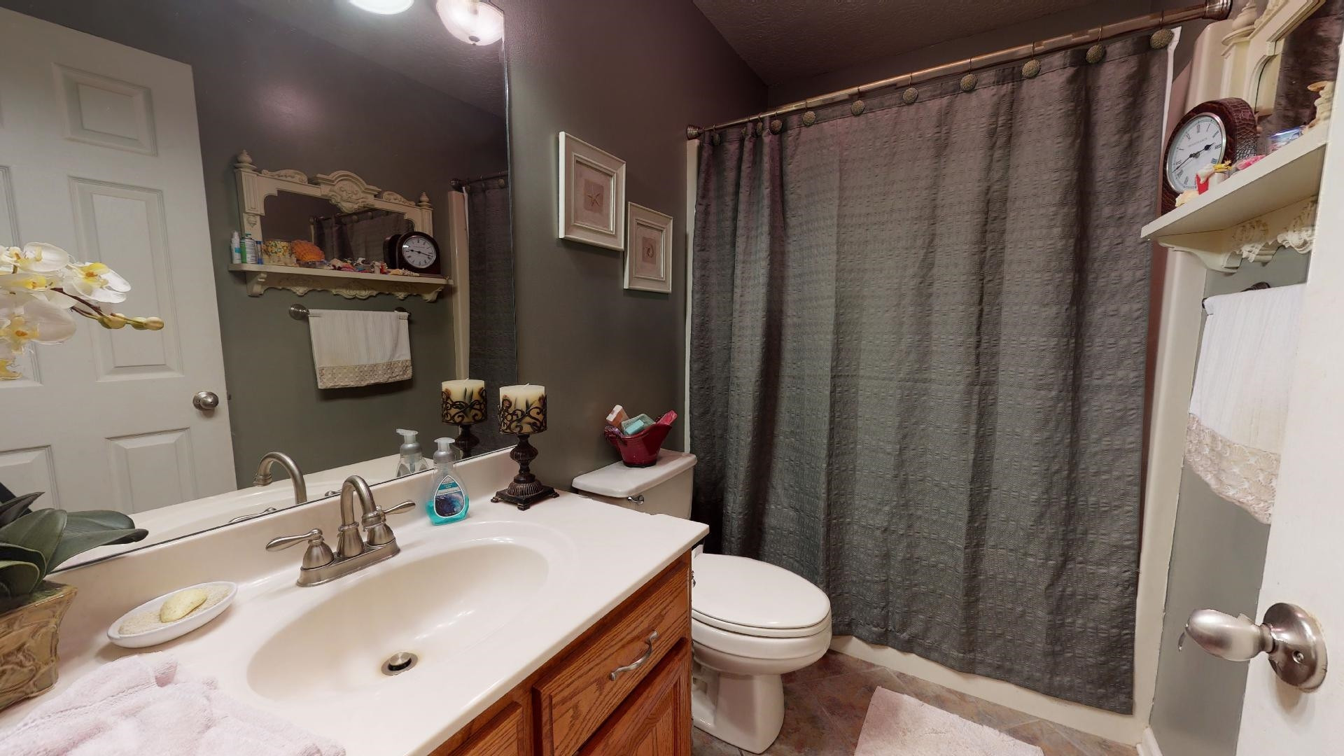 50 Bobby Thompson Road Newbern, TN 38059 - Photo 11 of 26 a bathroom with a sink a toilet and shower curtain