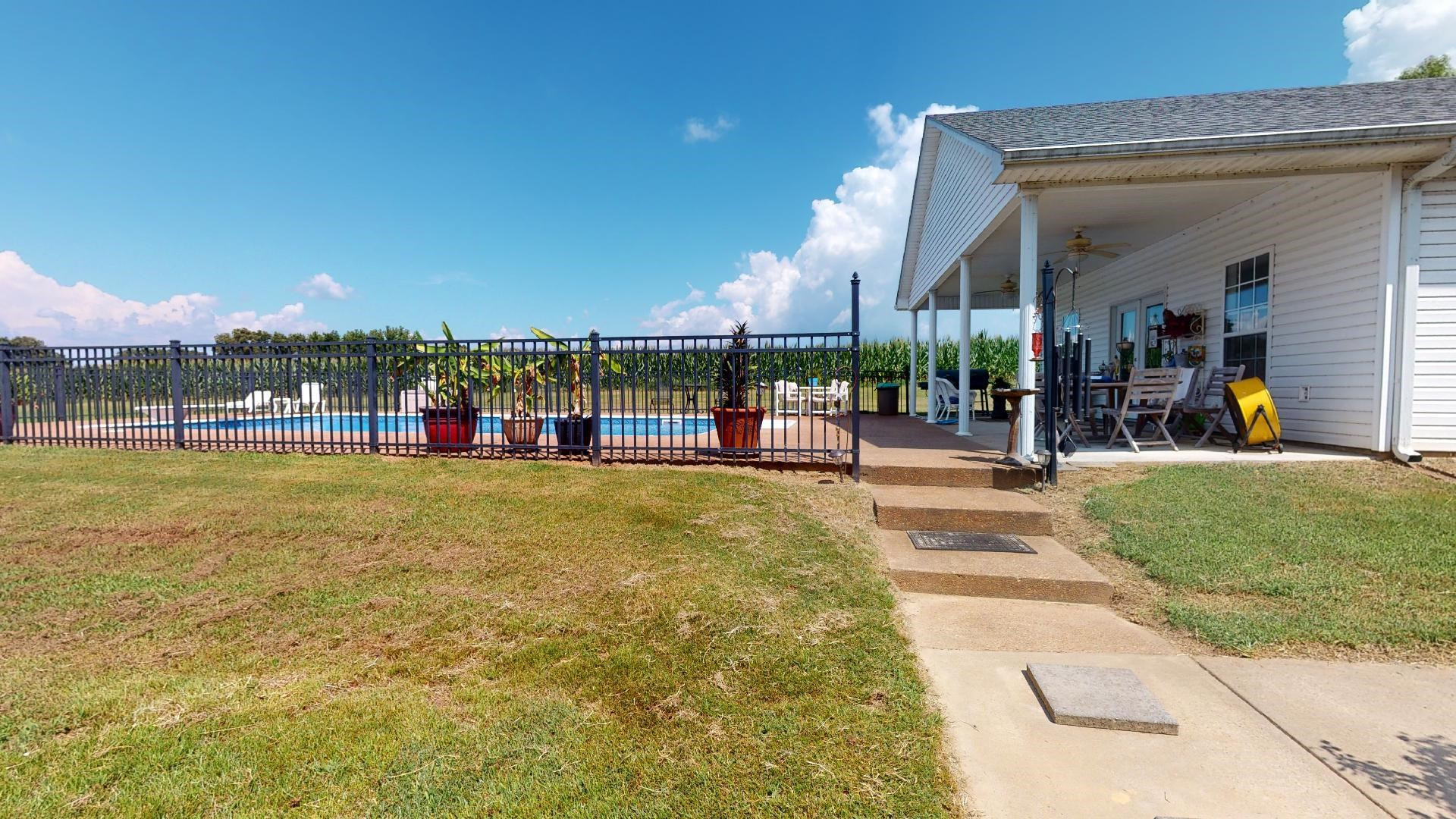 50 Bobby Thompson Road Newbern, TN 38059 - Photo 23 of 26 a view of a swimming pool with a lawn chairs under an umbrella