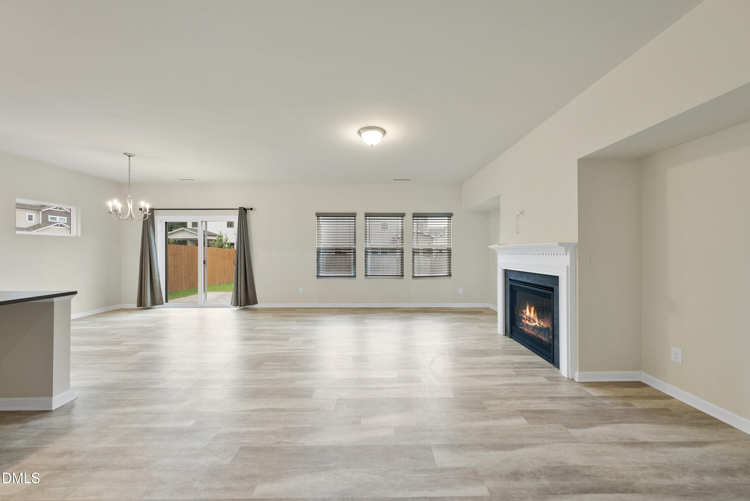 905 Lippincott Road Durham, NC 27703 - Photo 11 of 24 a view of an empty room with wooden floor fireplace and a window