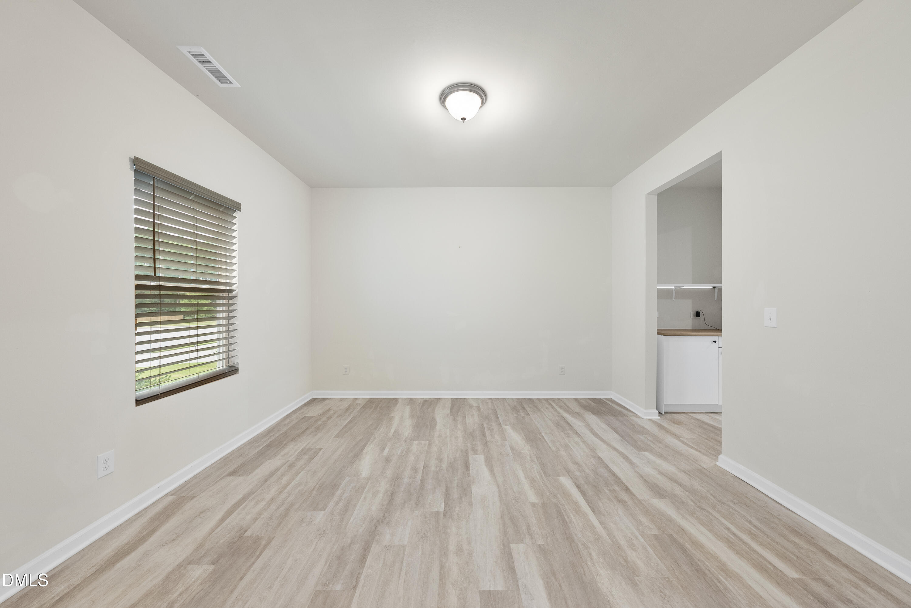 905 Lippincott Road Durham, NC 27703 - Photo 3 of 24 a view of an empty room with wooden floor and a window