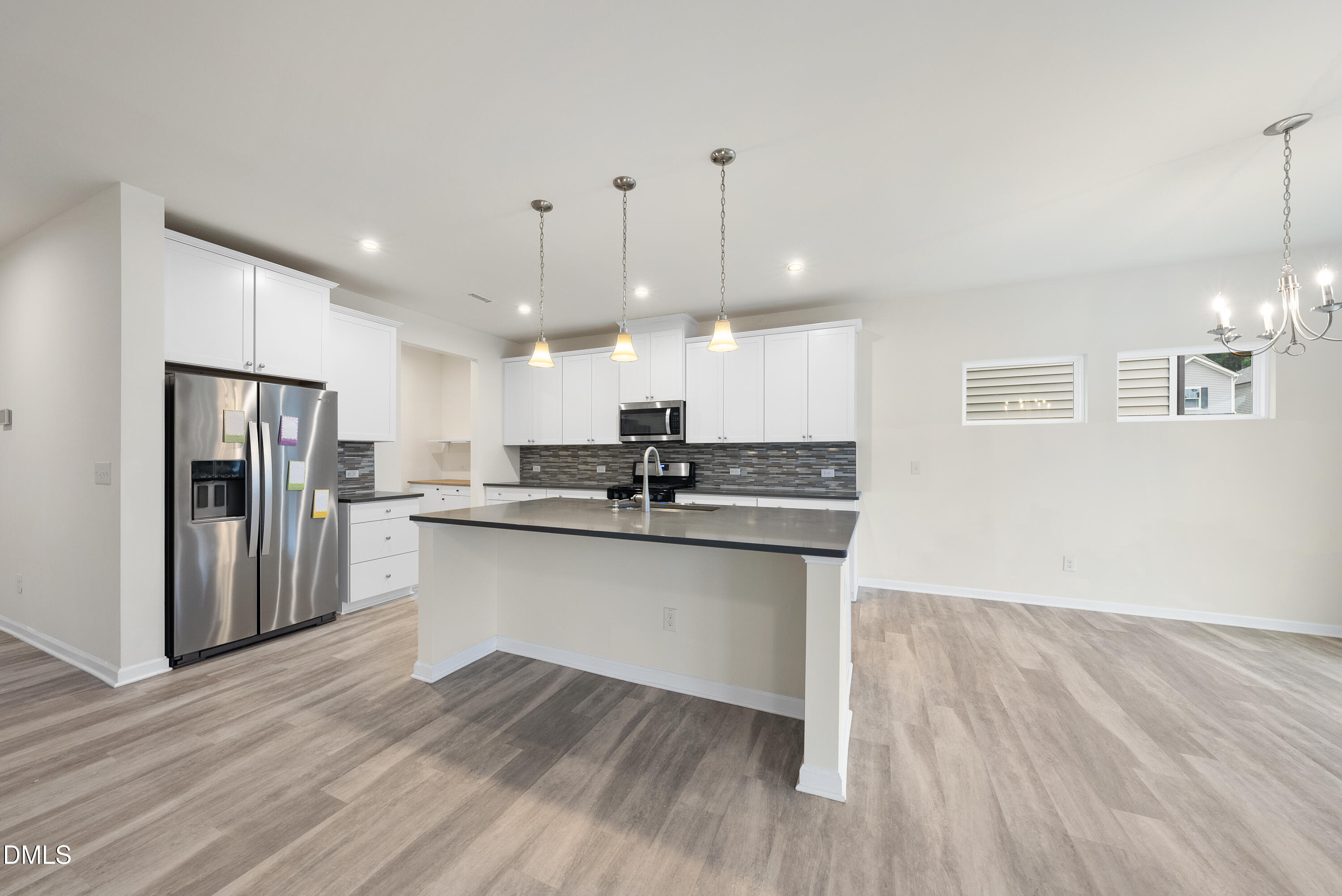 905 Lippincott Road Durham, NC 27703 - Photo 4 of 24 a kitchen with stainless steel appliances granite countertop a refrigerator a sink dishwasher a stove and white countertops with wooden floor