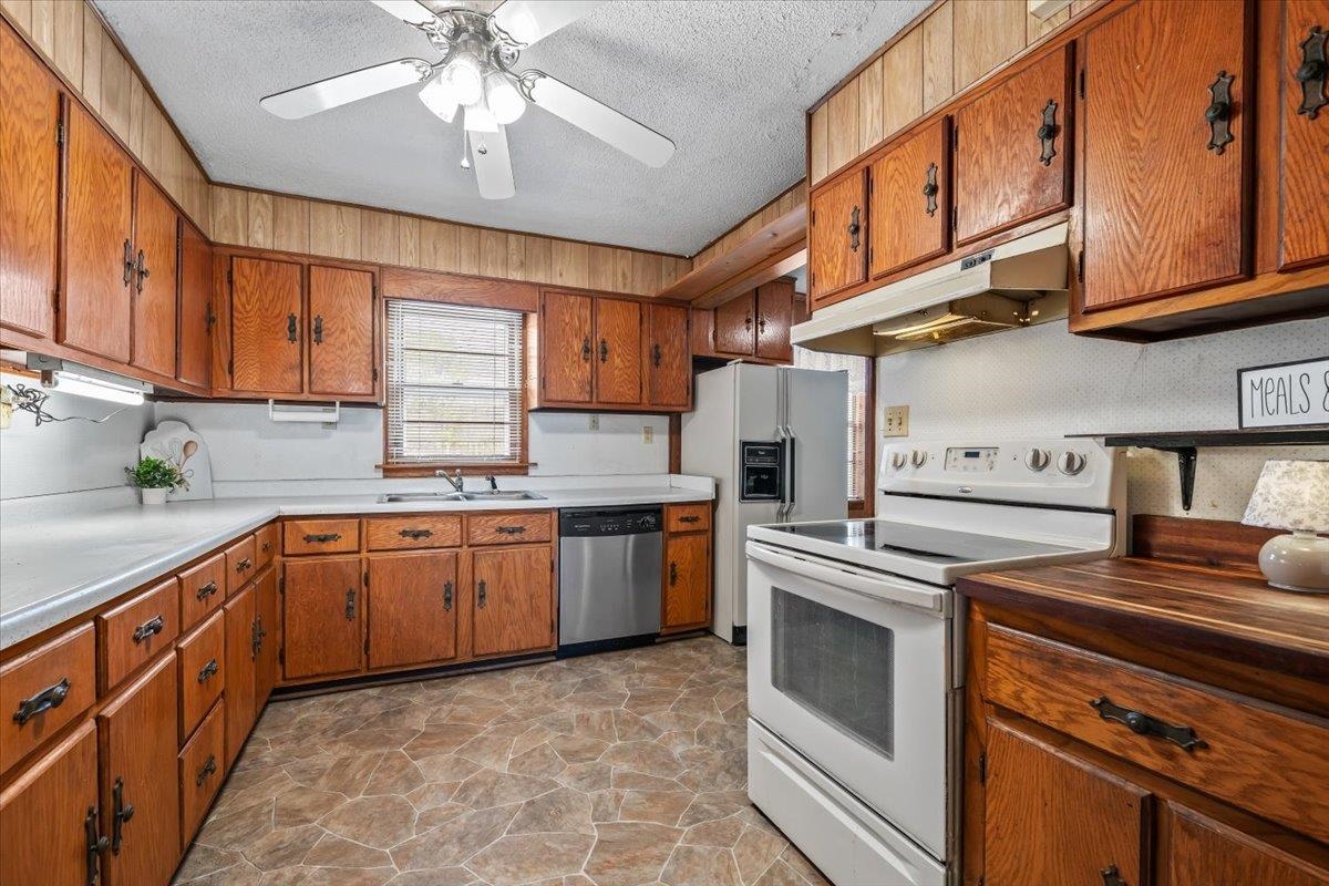 2972 Russell Bond Road Millington, TN 38053 - Photo 13 of 38 Kitchen with white appliances, wood finish cabinets, stone floors, and a textured ceiling