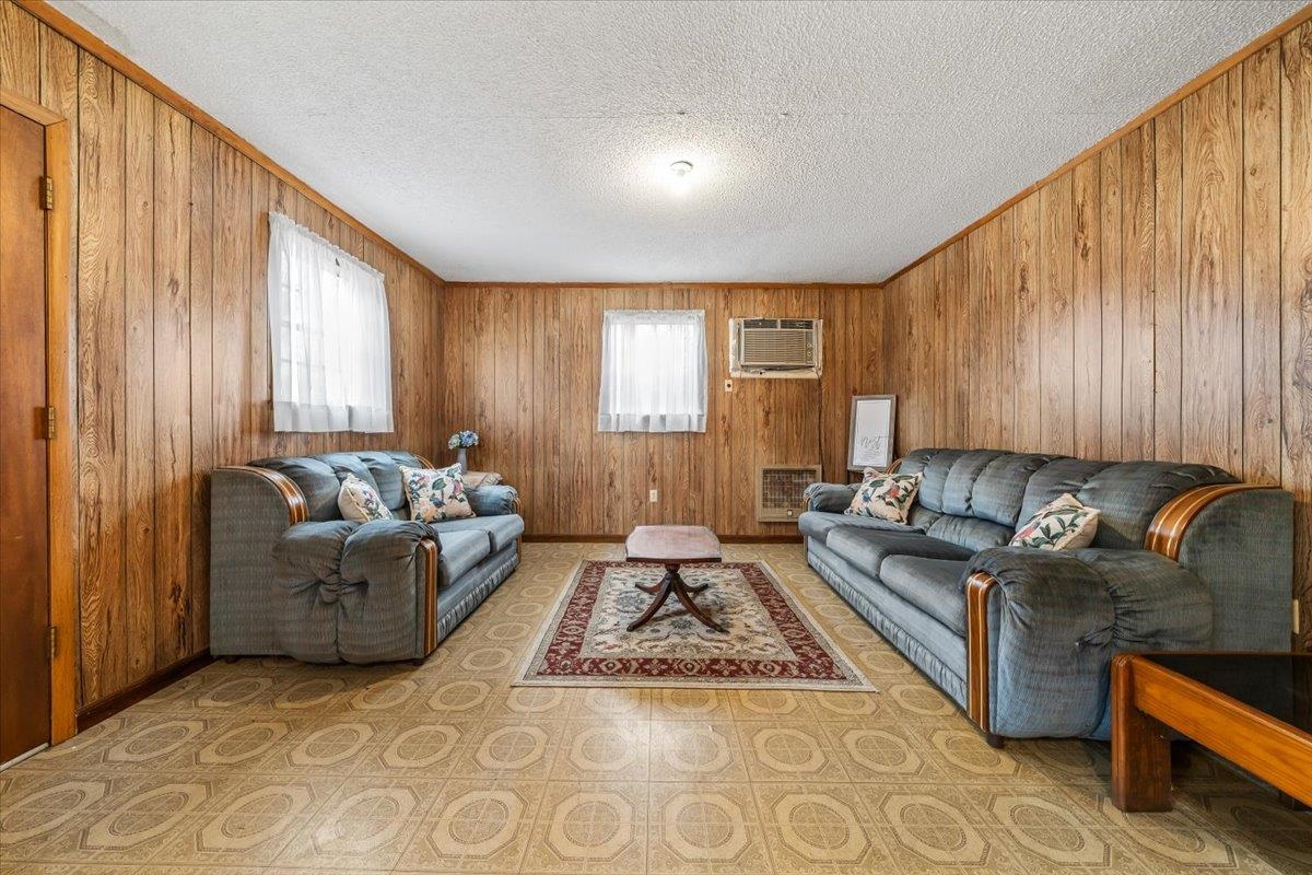2972 Russell Bond Road Millington, TN 38053 - Photo 27 of 38 Living room featuring light floors, wooden walls, a textured ceiling, and ornamental molding