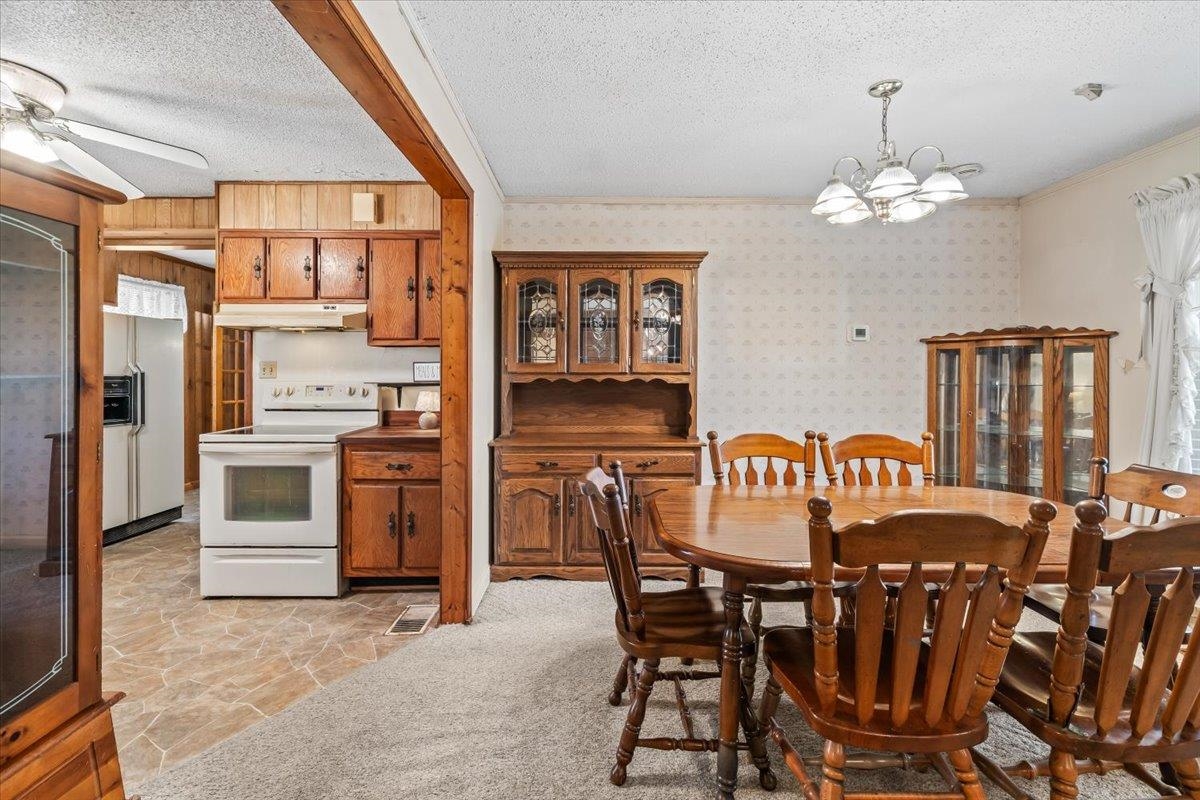 2972 Russell Bond Road Millington, TN 38053 - Photo 27 of 38 Dining room with stone flooring, a chandelier, a textured ceiling, a ceiling fan, and ornamental molding