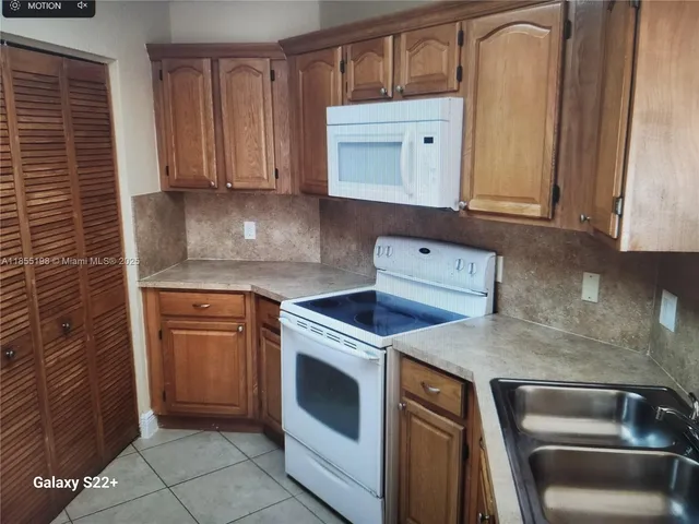 a kitchen with granite countertop white cabinets and stainless steel appliances