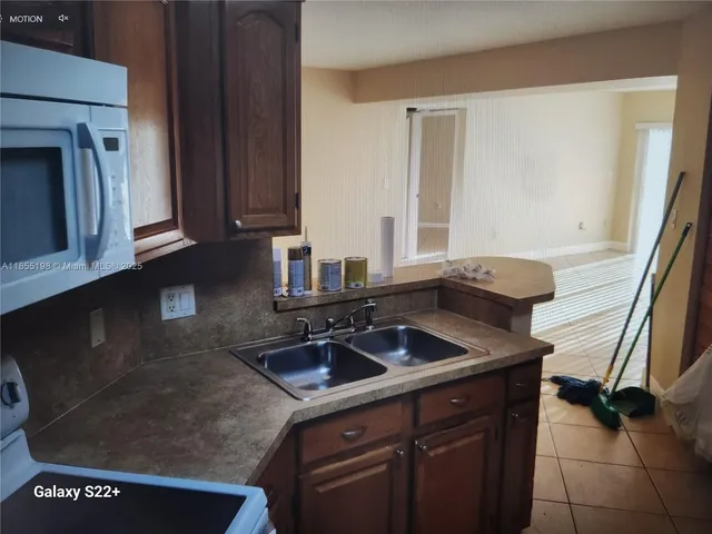 a kitchen with sink a stove and cabinets