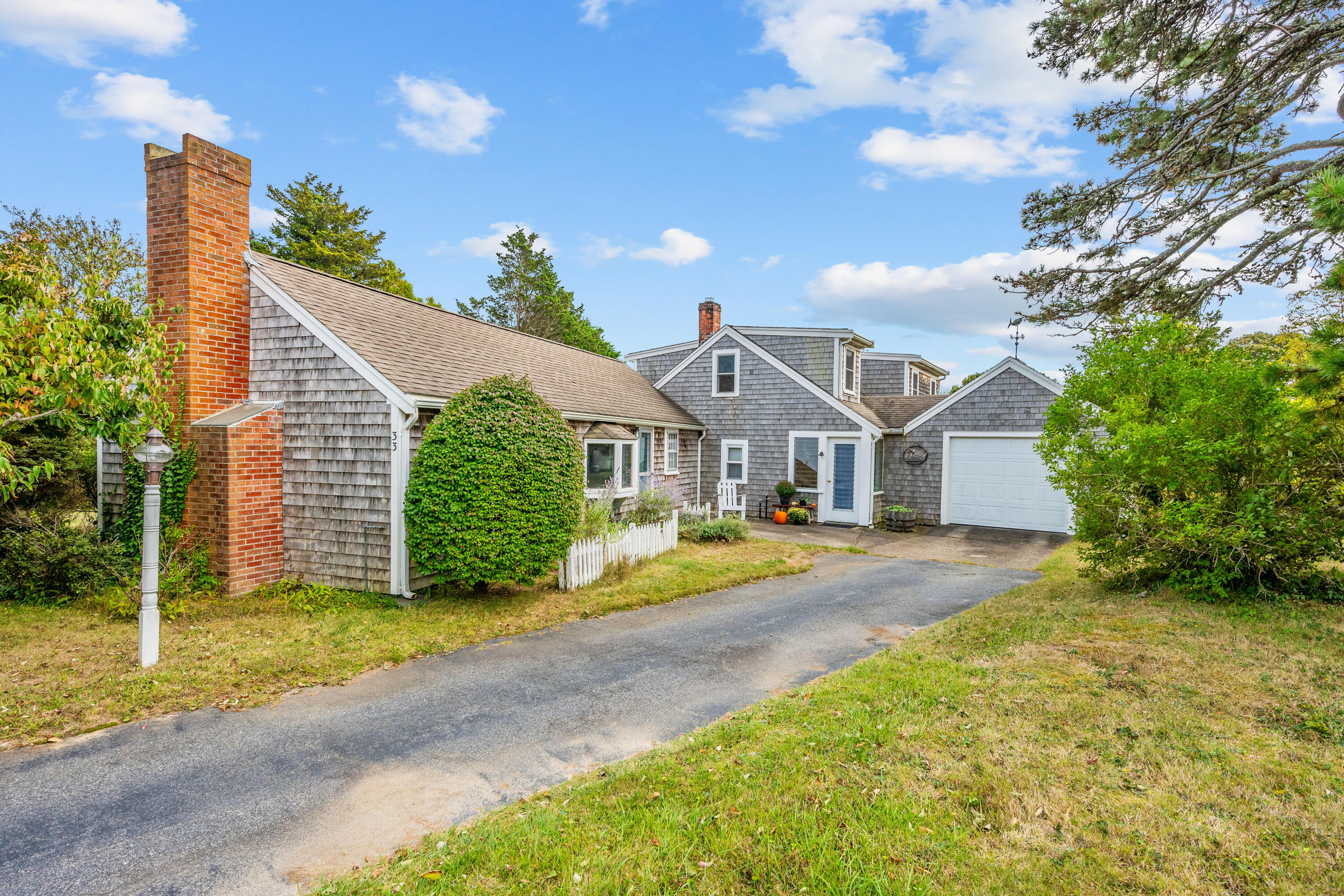 33 Mill Pond Road Orleans, MA 02653 - Photo 2 of 50 a front view of a house with a yard and garage