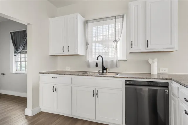 a kitchen with cabinets appliances a sink and a window