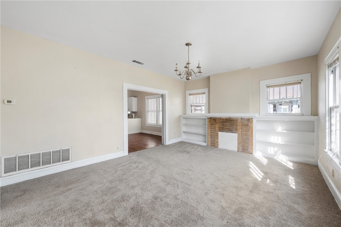 2012 North 5th Street Waco, TX 76708 - Photo 3 of 29 an empty room with chandelier and fireplace