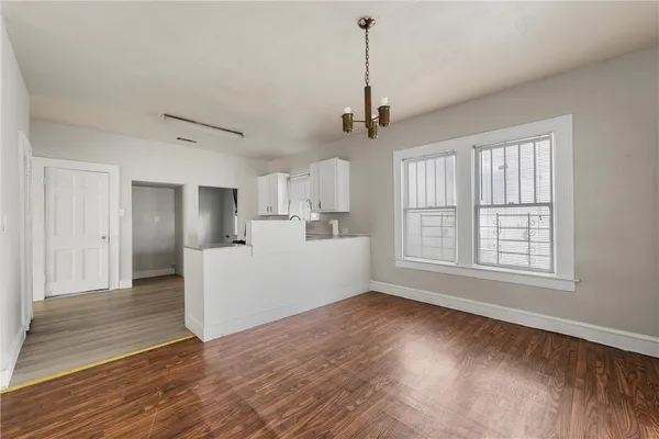 a view of empty room with wooden floor and window