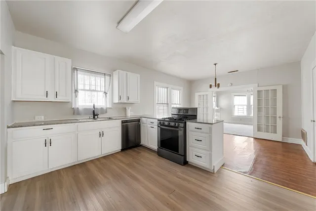 a kitchen with a refrigerator stove a sink and white cabinets