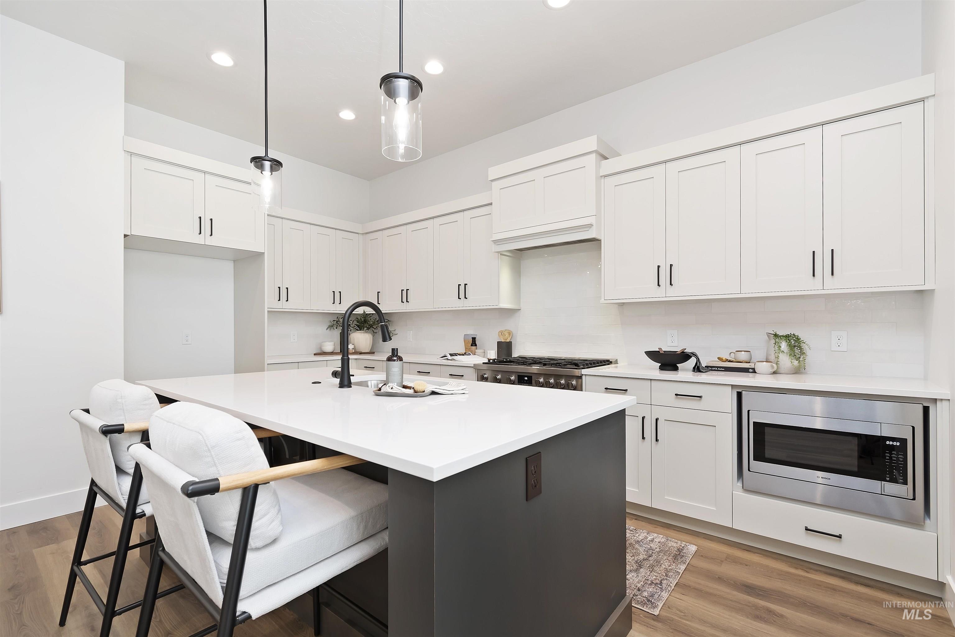 724 South Calhoun Lane Star, ID 83669 - Photo 1 of 46 Kitchen with decorative backsplash, pendant lighting, a kitchen breakfast bar, white cabinets, and recessed lighting