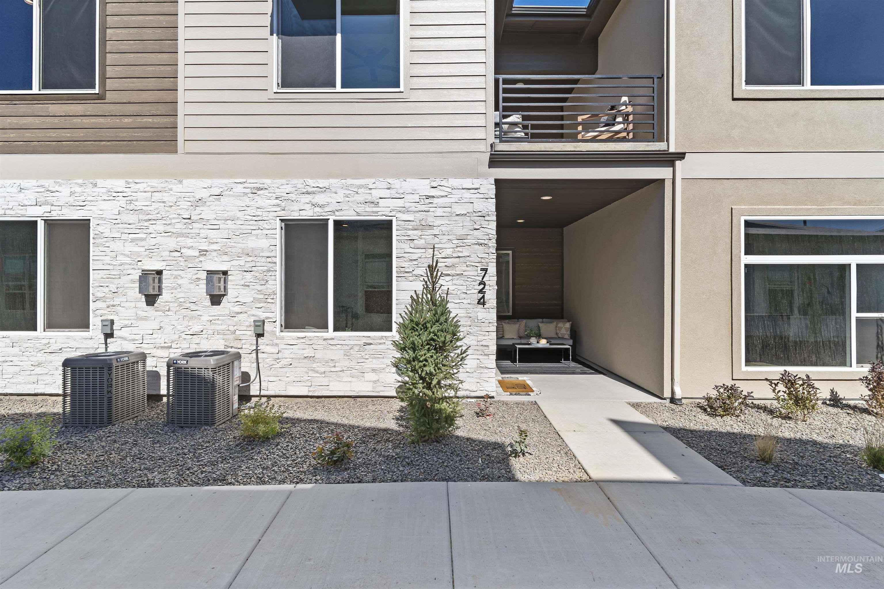 Property entrance with stone siding and stucco siding