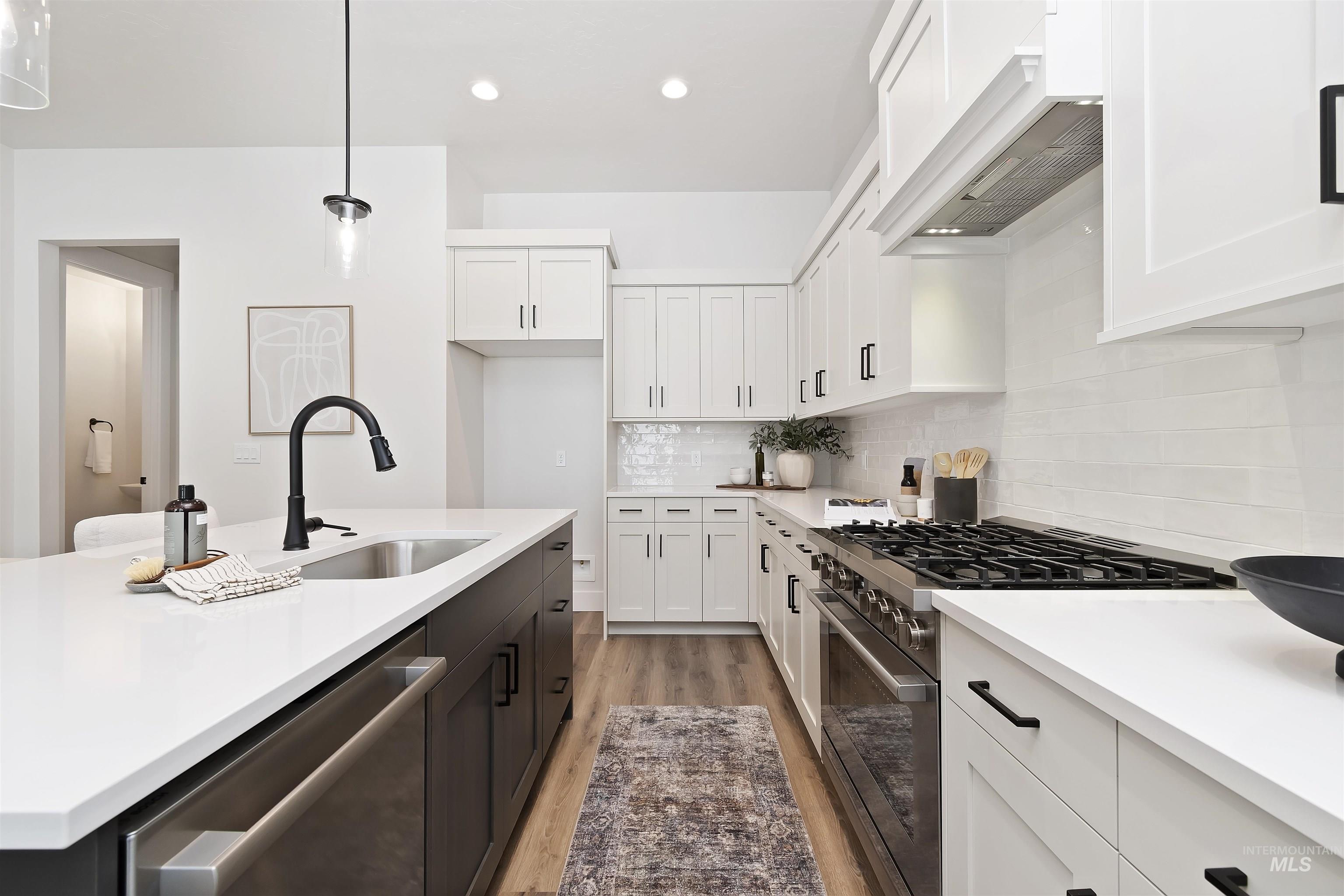 724 South Calhoun Lane Star, ID 83669 - Photo 12 of 44 Kitchen with appliances with stainless steel finishes, light wood-style floors, white cabinets, custom exhaust hood, and recessed lighting