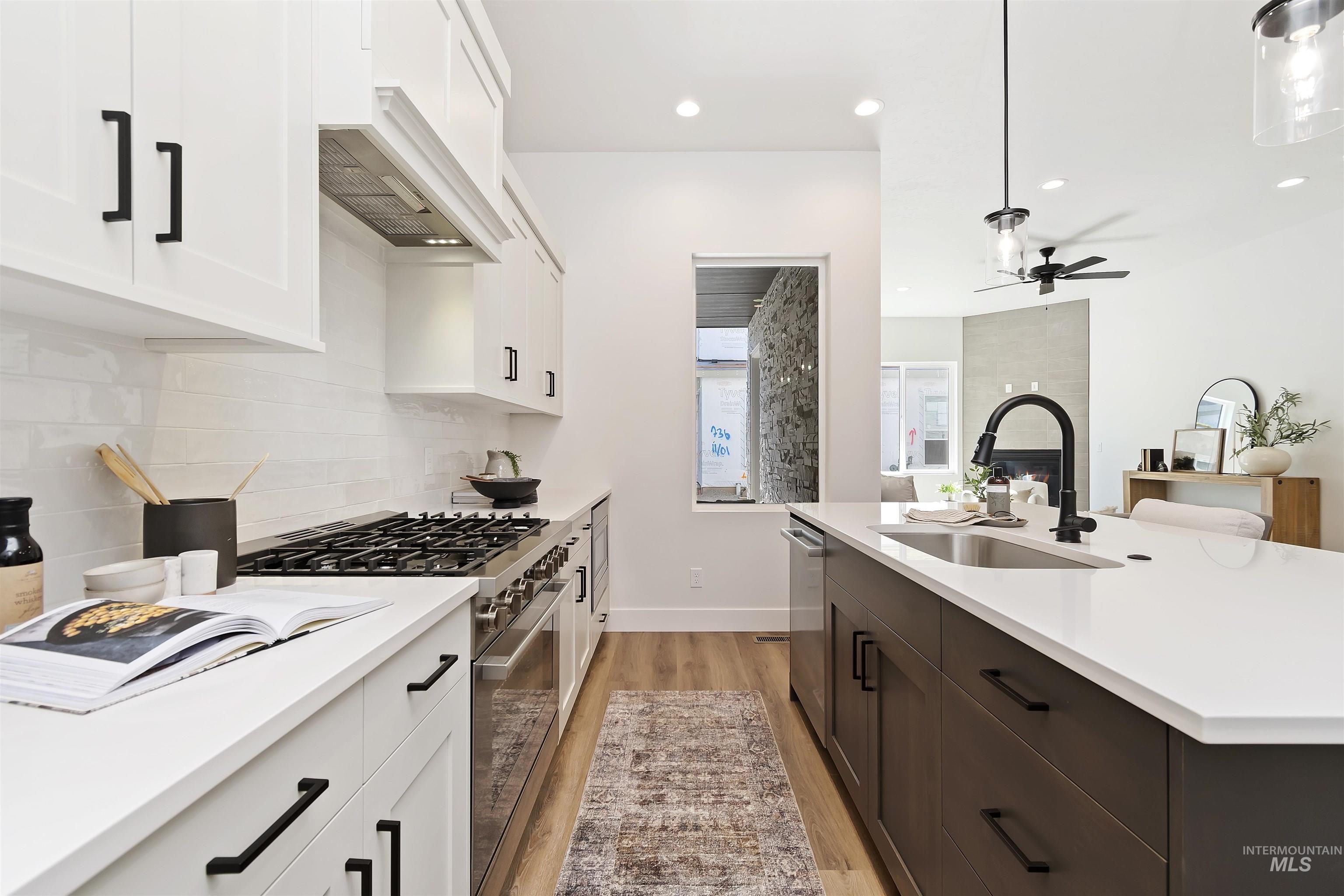 724 South Calhoun Lane Star, ID 83669 - Photo 13 of 44 Kitchen featuring light wood-type flooring, stainless steel appliances, white cabinets, decorative light fixtures, and recessed lighting