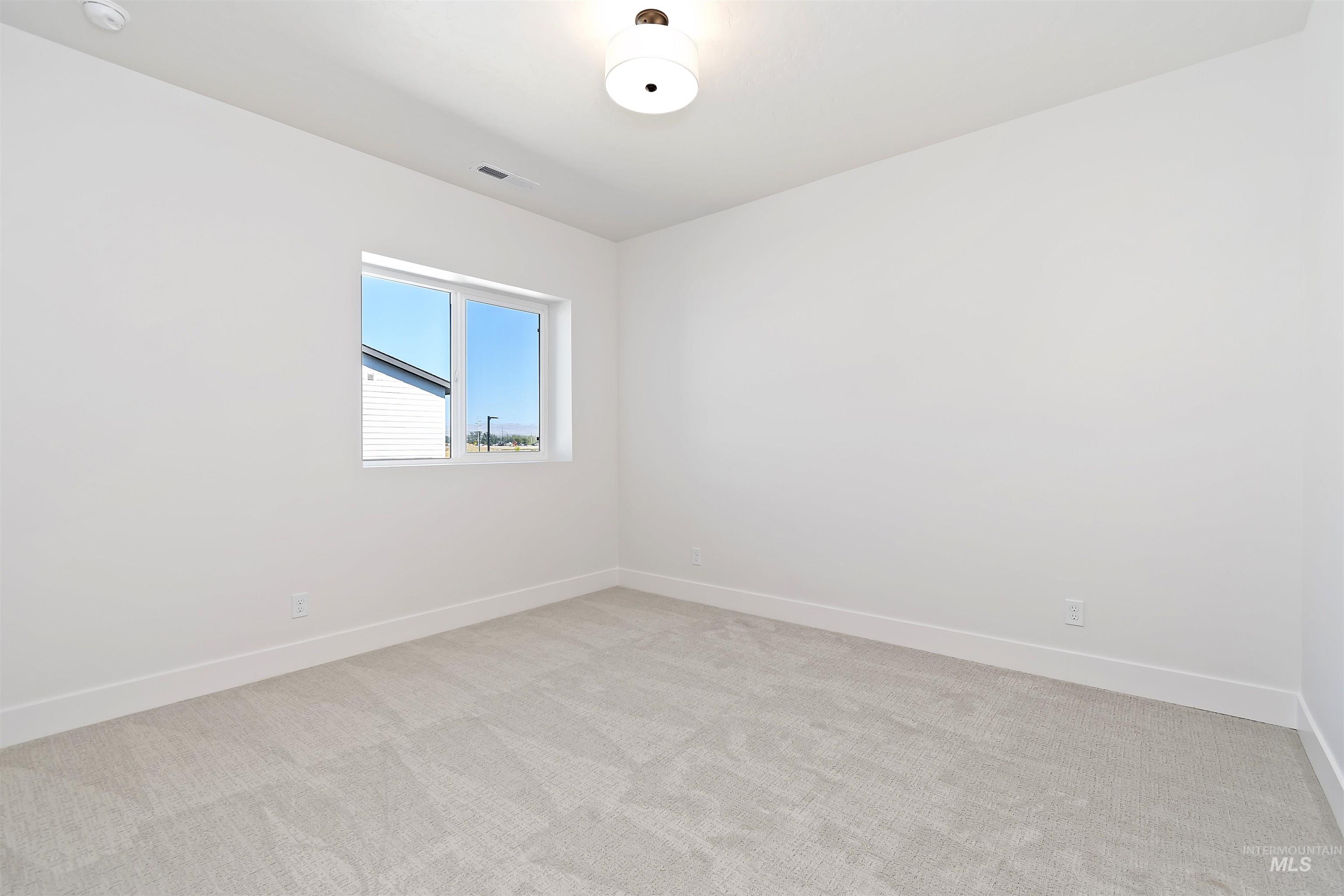 724 South Calhoun Lane Star, ID 83669 - Photo 32 of 46 Empty room with light colored carpet and baseboards