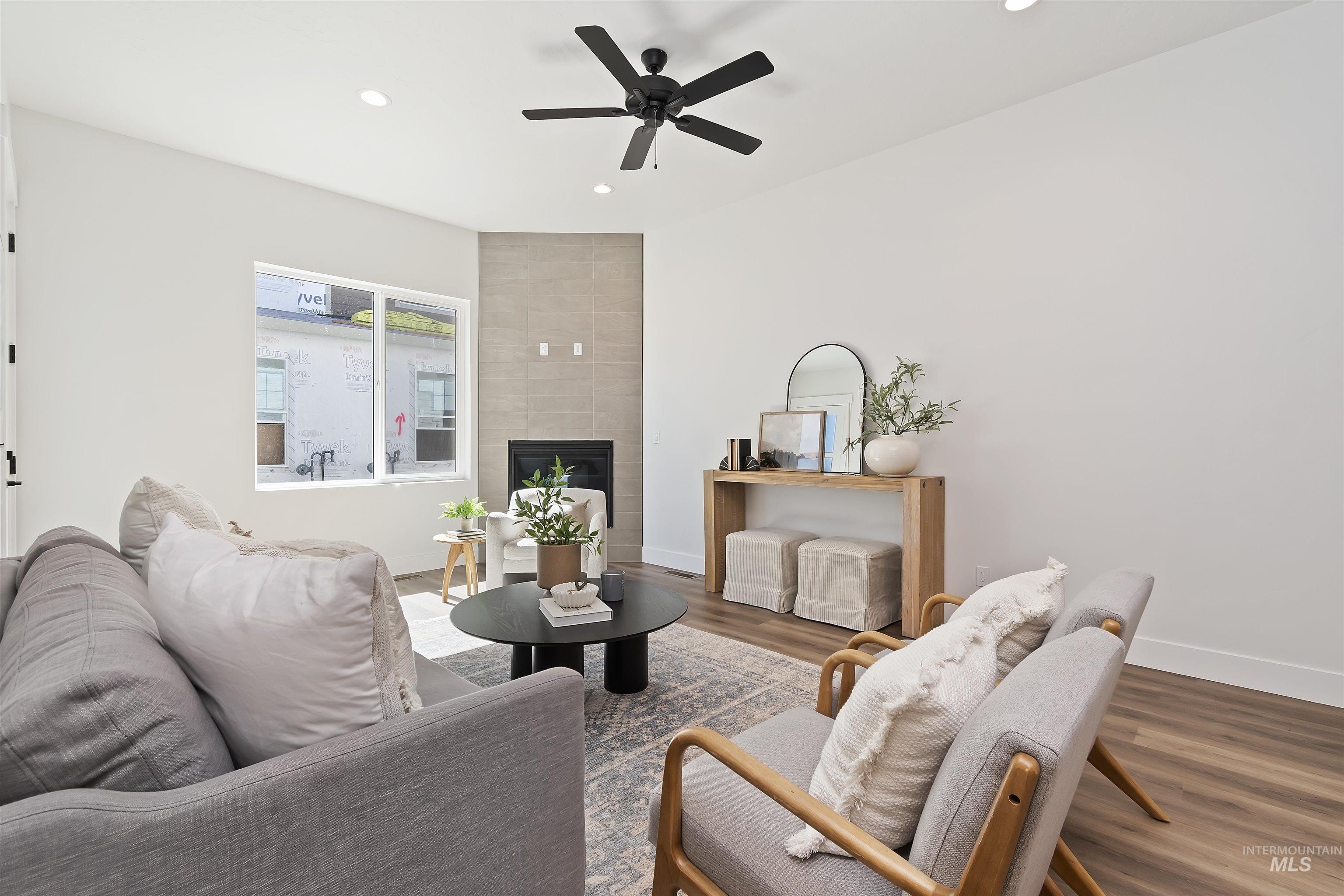 724 South Calhoun Lane Star, ID 83669 - Photo 5 of 44 Living area featuring recessed lighting, a tile fireplace, wood finished floors, and a ceiling fan