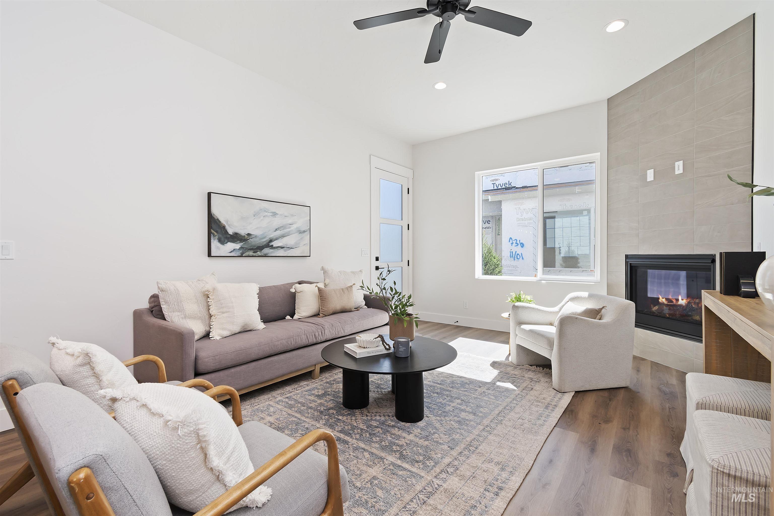 724 South Calhoun Lane Star, ID 83669 - Photo 6 of 44 Living room featuring wood finished floors, a fireplace, recessed lighting, and a ceiling fan