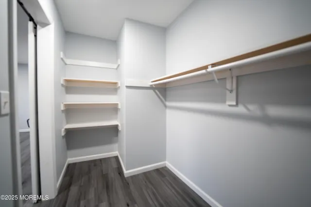 an empty room with a window and a chandelier fan
