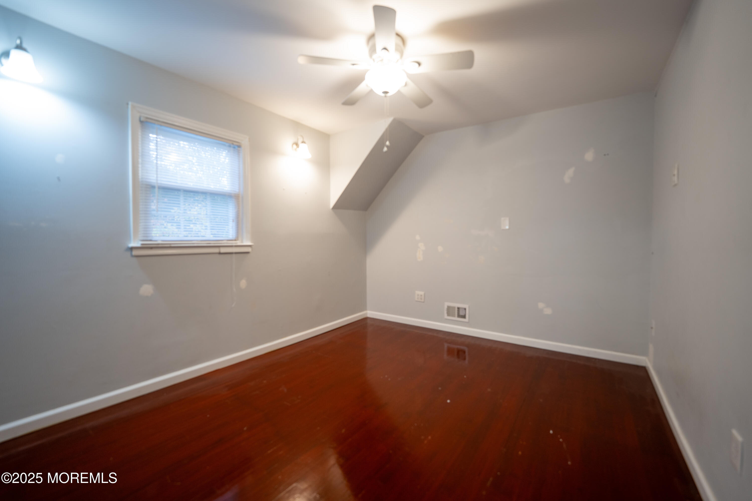 813 Raleigh Drive Toms River, NJ 08753 - Photo 14 of 28 an empty room with a window and a chandelier fan