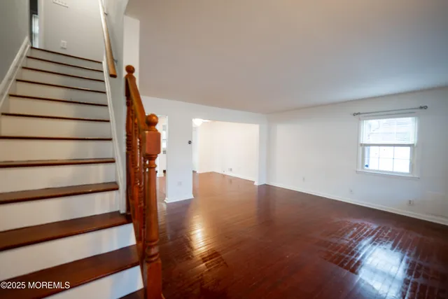 a view of a room with wooden floor and a kitchen