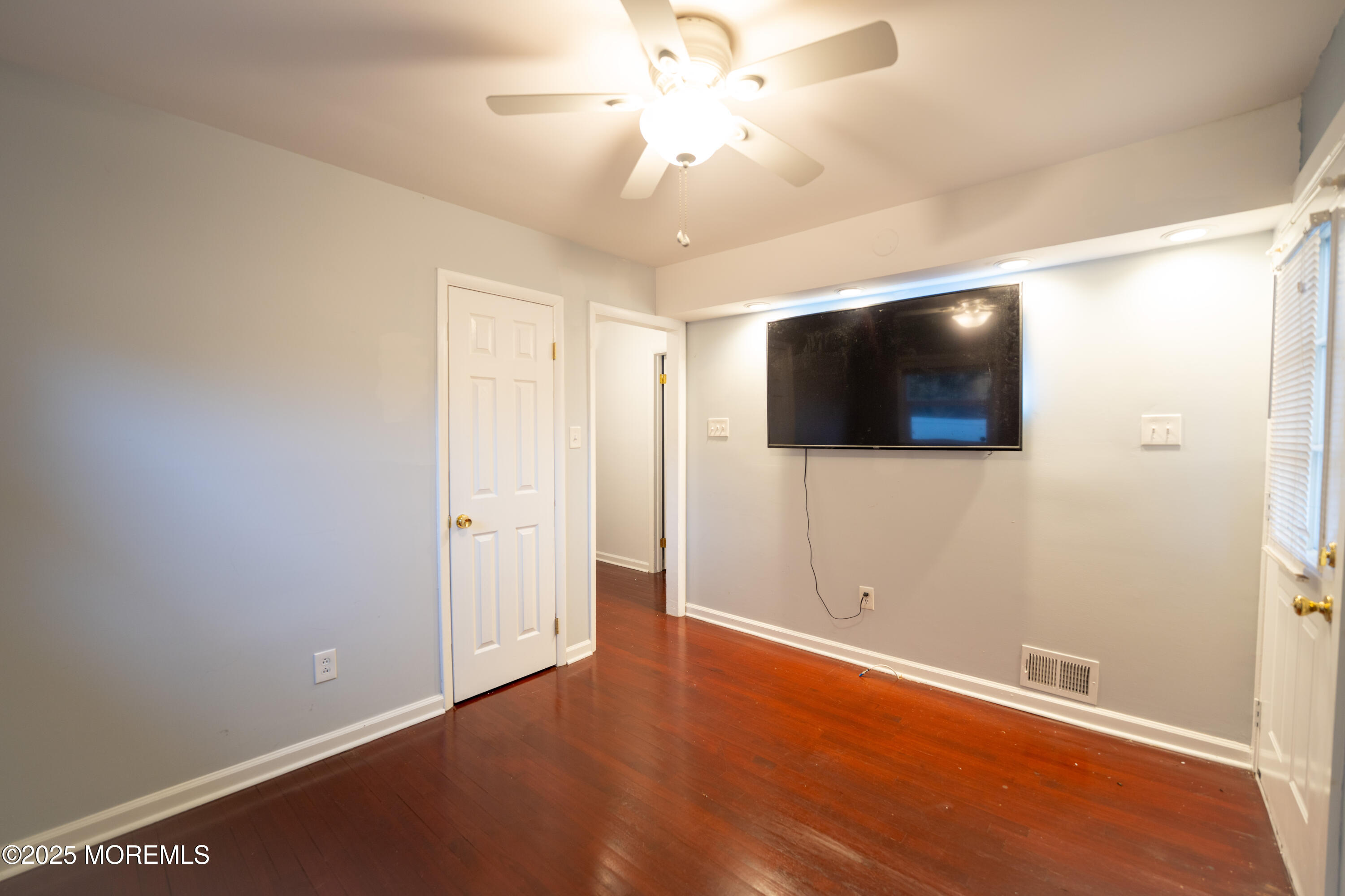813 Raleigh Drive Toms River, NJ 08753 - Photo 9 of 28 an empty room with wooden floor and windows