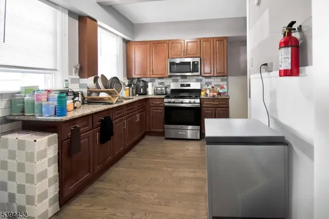 a kitchen with stainless steel appliances granite countertop a sink stove microwave and refrigerator