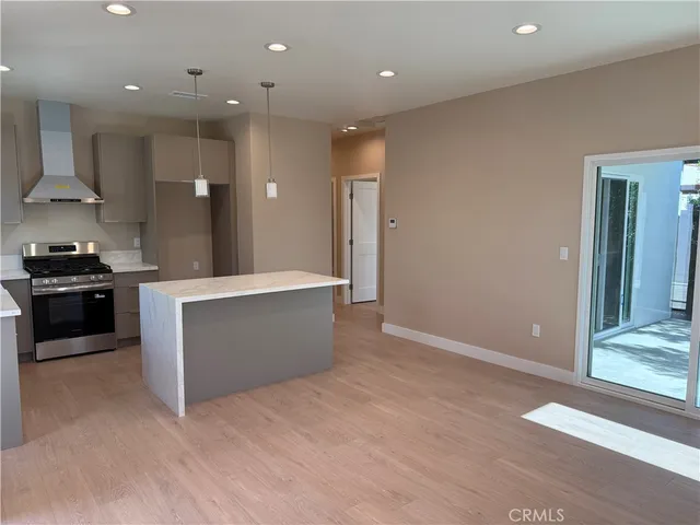 a large kitchen with stainless steel appliances a large counter top