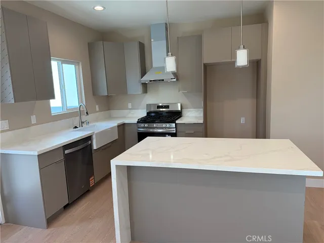 a kitchen with kitchen island sink a stove and refrigerator