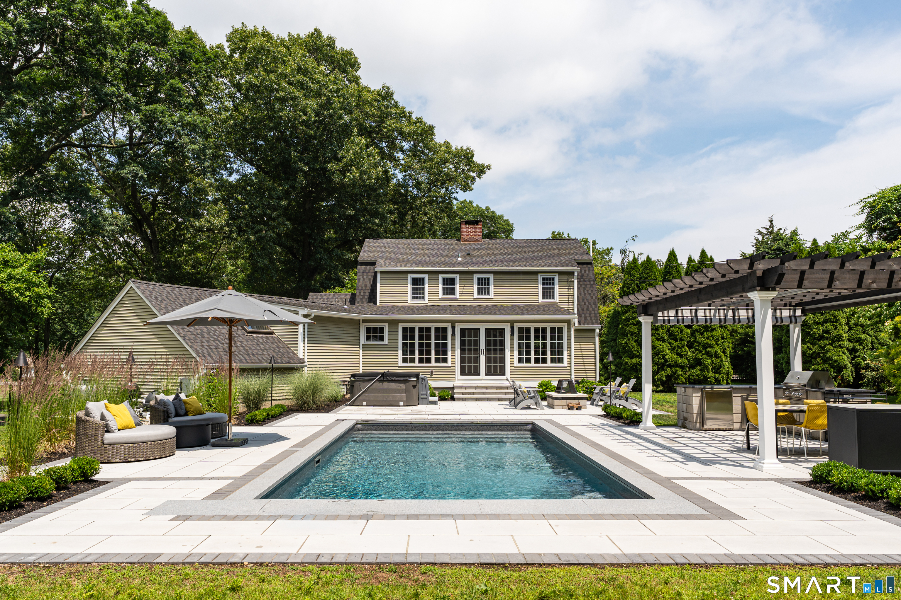 33 River Edge Farms Road Madison, CT 06443 - Photo 3 of 40 Spend every summer surrounded by luxury with a heated saltwater pool, granite coping, and an automatic pool cover for effortless enjoyment.