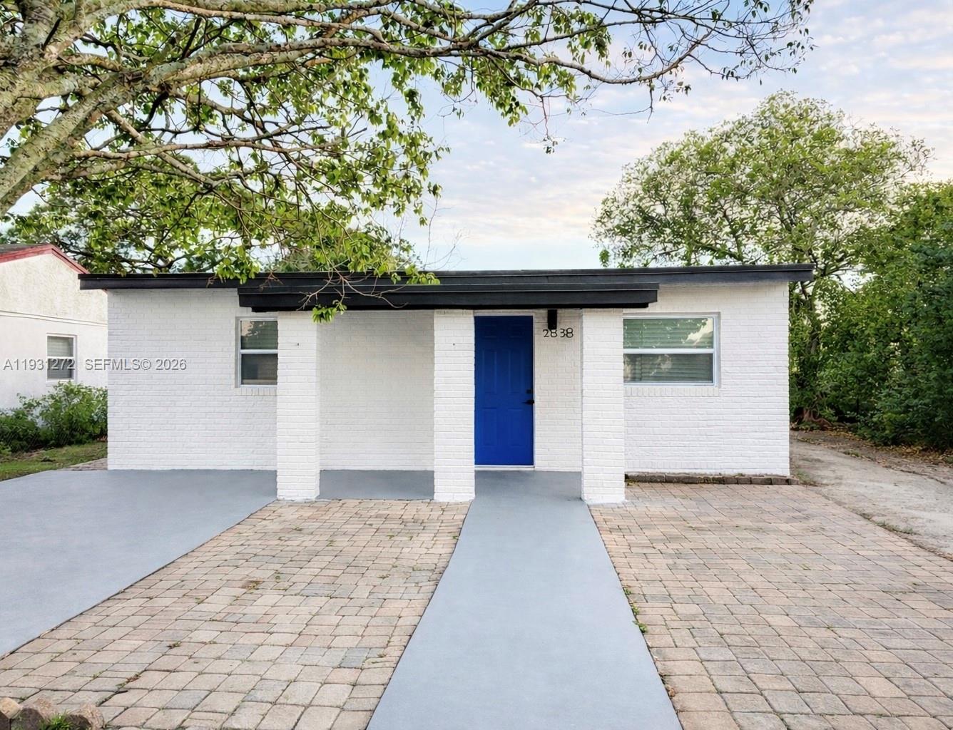 a front view of a house with a garden